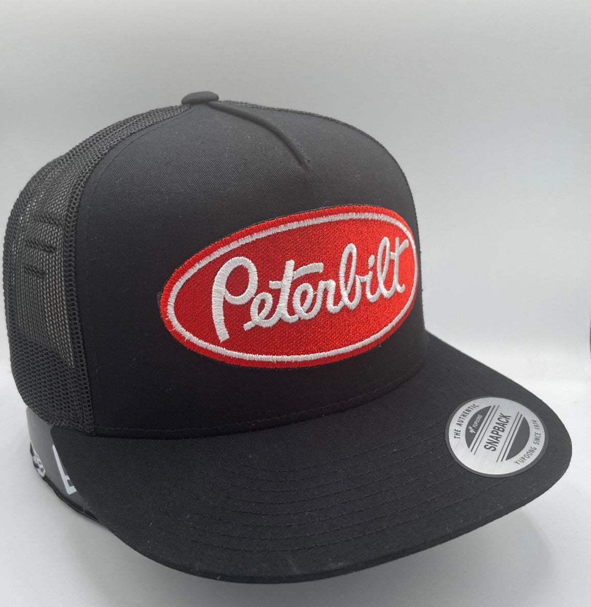 Gorra de béisbol bordada con visera plana de malla y cierre a presión de Peterbilt, color negro